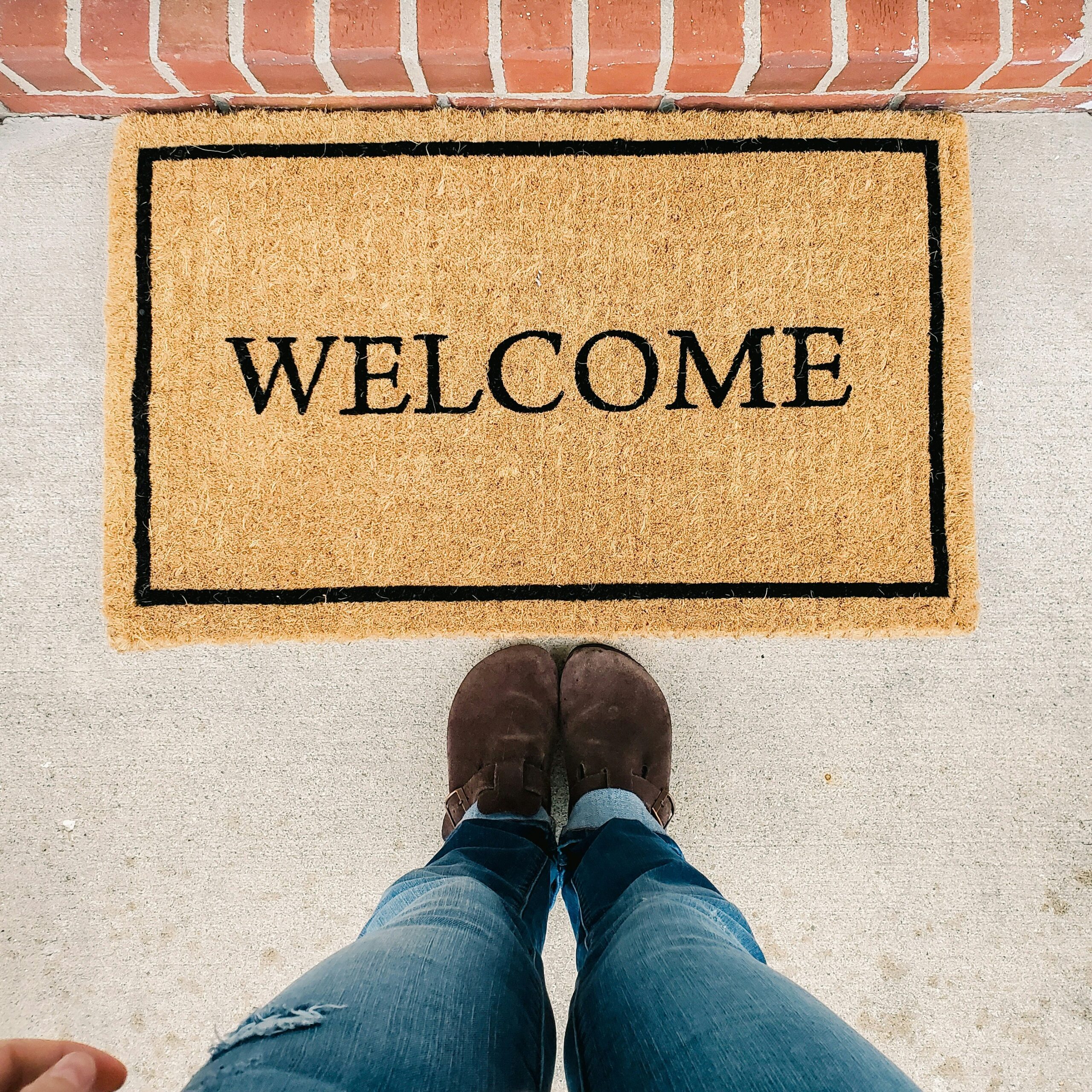 person standing by welcome mat