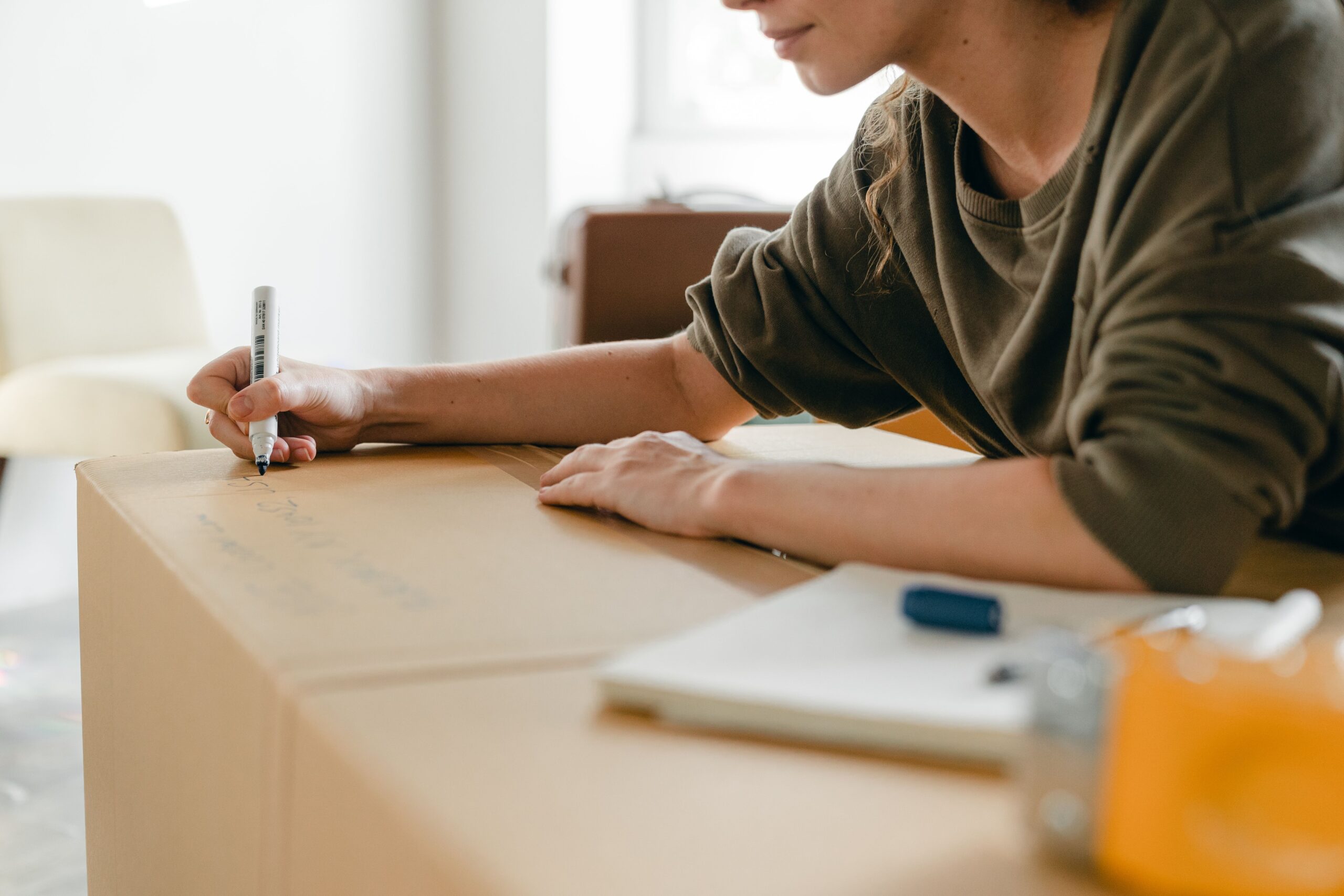 woman marking a moving box